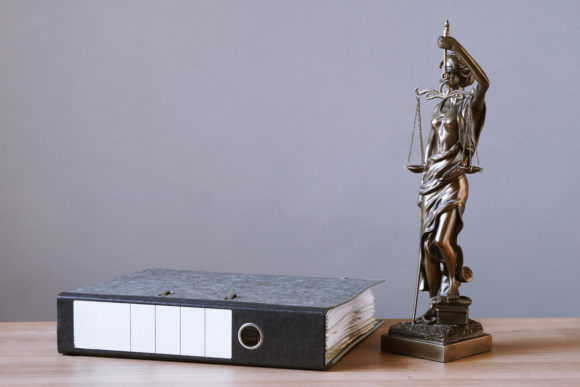 Lady Justice or Justitia Statue and File Folder on Desk Graphic Abstract By axel.bueckert